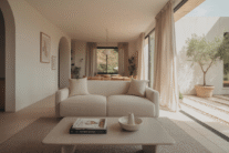 Neutral home decor ideas featuring modern living room and dining space with beige sofa, white walls, and wood accents.